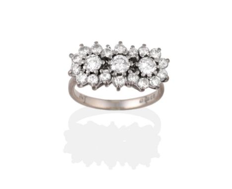 An 18 Carat White Gold Diamond Cluster Ring, a central row of three round brilliant cut diamonds within a border of round bri