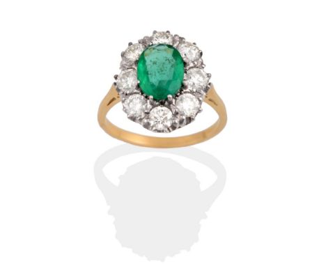 An Emerald and Diamond Cluster Ring, the oval cut emerald within a border of round brilliant cut diamonds, in white claw sett