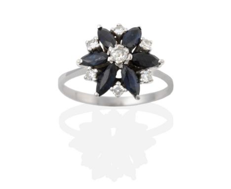 A Sapphire and Diamond Cluster Ring, a round brilliant cut diamond centres a cluster of six marquise cut sapphires, a smaller