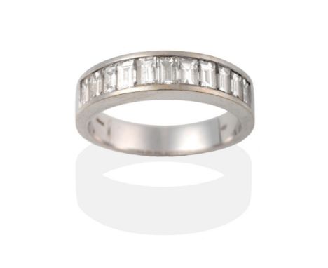 An 18 Carat White Gold Half Hoop Ring, eleven graduated baguette cut diamonds in a channel setting, on a plain polished shank