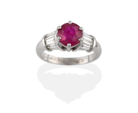 An 18 Carat White Gold Ruby and Diamond Ring, a round cut ruby claw set with tapered baguette cut diamonds set around the sho