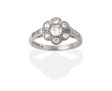 A Palladium Diamond Cluster Ring, the round brilliant cut diamonds in white claw settings, to shoulders channel set with a ve