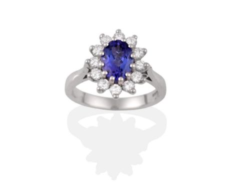 An 18 Carat White Gold Tanzanite and Diamond Cluster Ring, the oval cut tanzanite within a border of round brilliant cut diam