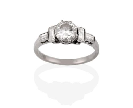 An Early 20th Century Diamond Ring, a round brilliant cut diamond centrally in white claw settings, a baguette cut diamond se