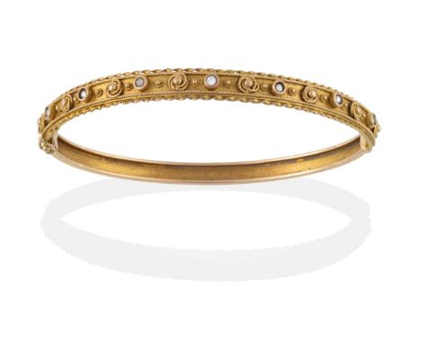 A 14 Carat Gold Bangle, of decorative form, one half with a diamond and several split pearls inset along the length, with rop