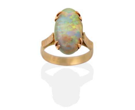 An Opal Ring, the oval cabochon opal in a yellow double claw setting to linear decorated shoulders on a plain polished shank,