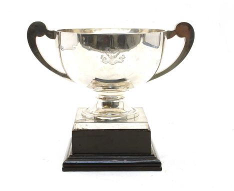 A George V silver twin handled trophy with scroll handles and square plinth base, inscribed 'Presented to Hamo Douglas Thorne