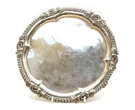 A George II silver salver, London 1757, maker W.B. with an engraved crest and shell and gadroon border, 26cm diameter, approx