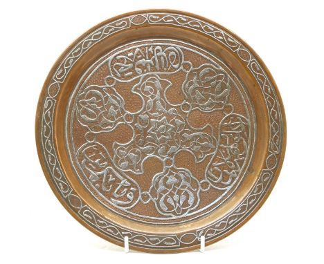 A Cairoware circular heavy copper tray, with inlaid silver engraved interwoven leaf pattern and Arabic caligraphic inscriptio