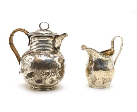 A George III silver cream jug, London 1802, 12cm, and a silver Jersey cream jug, hallmarks indistinct, 15cm high (2)Provenanc