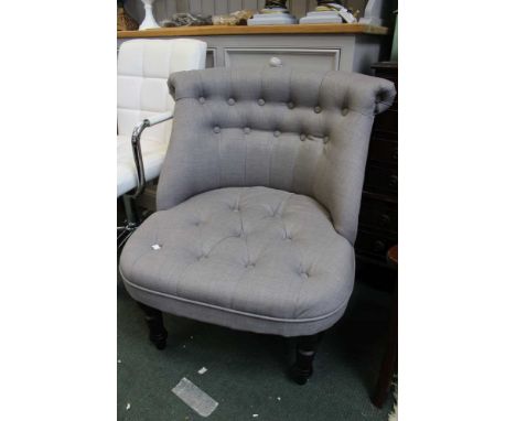 A modern grey upholstered button back easy chair