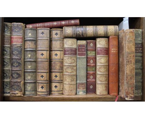 A shelf containing 14 leather bound decorative books with some hinges cracked and bindings worn