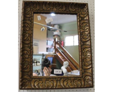 A vintage wooden carved frame and gilded wall mirror
