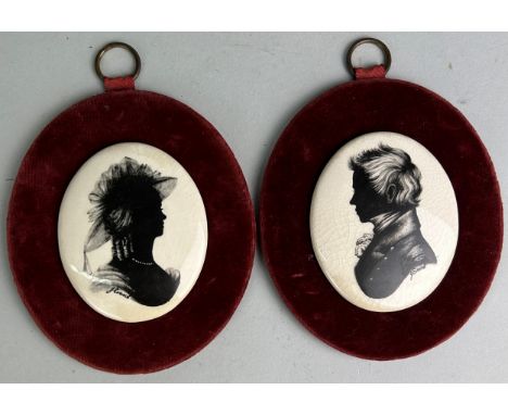 A PAIR OF CERAMIC SILHOUETTES ON RED VELVET (2) 