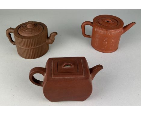 A COLLECTION OF THREE CHINESE YIXING CLAY TEAPOTS (3) One with reeded design and faux bamboo handles, another with archaic Ch