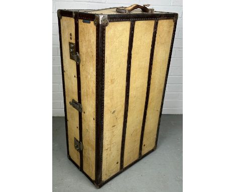 A LARGE BEIGE TRAVEL WARDROBE TRUNK WITH FITTED INTERIOR 
