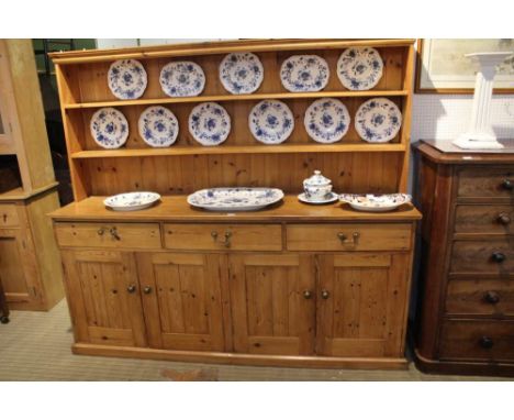 A 20TH CENTURY LARGE SIZED PINE DRESSER with twin shelf plate rack back, the base section having three inline drawers, over f