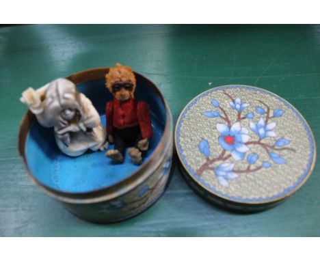AN ORIENTAL FLORAL CLOISONNE CIRCULAR LIDDED POT, containing a felt covered cast metal monkey and an Oriental netsuke figure 