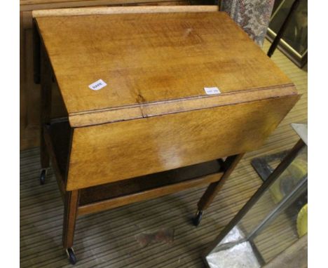 A LIGHT OAK TWIN FLAP TOPPED TWO-TIER SERVING TROLLEY 