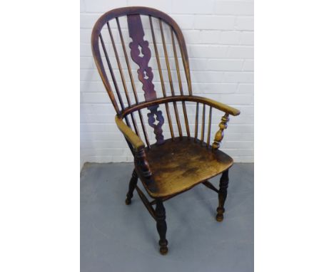 A 19th century Windsor armchair having a spindle back over moulded seat raised on turned supports and stretchers 