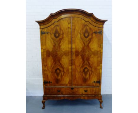 A burr walnut wardrobe having a moulded dome top over two panel doors and one long drawer to base, raised on cabriole legs an