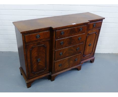 A mahogany breakfront sideboard of small proportions having a moulded top over four graduating drawers flanked by panel door 