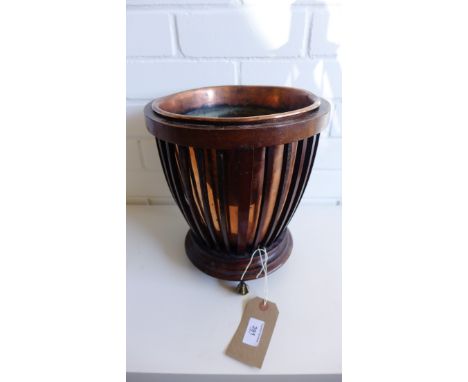 A 19th century mahogany planter, the cylindrical bowl with spindles enclosing a copper  insert, all raised on brass claw and 