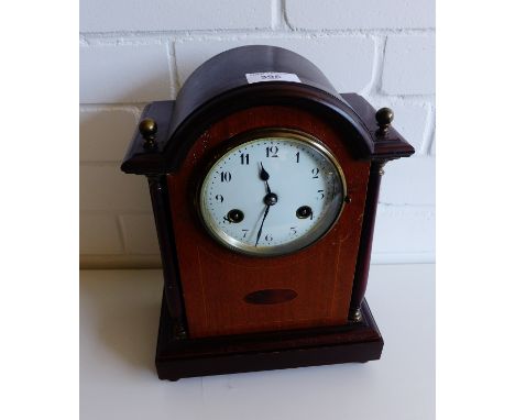 An Edwardian mahogany and inlaid dome top mantle clock,  the enamel dial flanked by columns, raised on bun feet, 24 x 33cm  