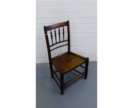 A 19th century elm child's chair having a spindle back support over panel seat raised on turned supports and stretchers 