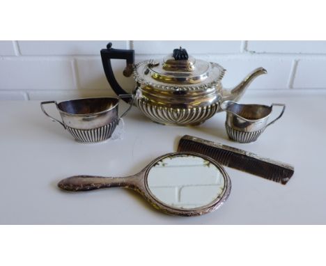 Silver three piece half lobed teaset, with mixed hallmarks together with a silver backed dressing table mirror and comb (5) 