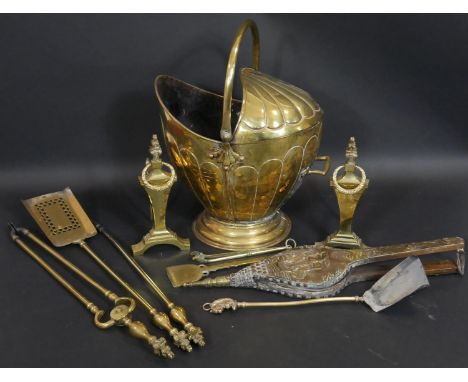 A 19th century embossed brass helmet form coal bucket and a set of three 19th century fire tools along with a pair of fire do
