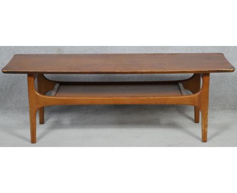 A mid century vintage teak coffee table on shaped supports united by undertier. H.40 L.116.5 W.41cm 