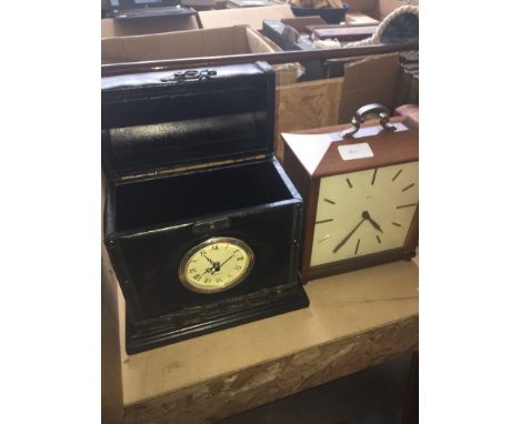 A Smiths mantel clock in sarcophagus shape and a quartz clock in shape of a carry box. 
