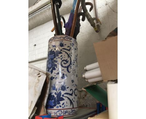 A blue and white stick stand with umbrellas and walking sticks Overall condition is good.