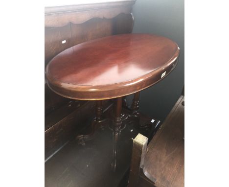 A 19th century mahogany pedestal occasional table with oval top raised on four turned pillars with scroll feet and ceramic ca