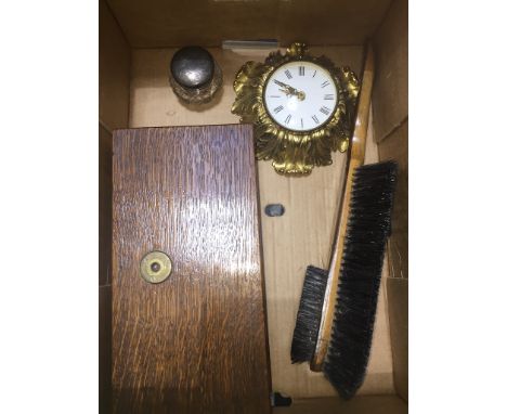 A box of collectables to include small brass wall clock, boxed weighing scales, brush and a hallmarked silver jar. 