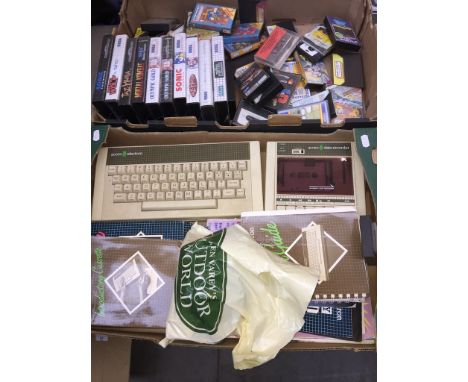 A vintage Acorn Electron game console with additional games, cassette games, manual, a bag of related games and a box of Sega