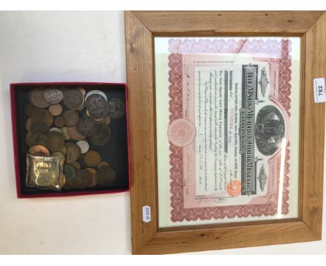 A  1909 gold share certificate in frame and a small collection of coins. 