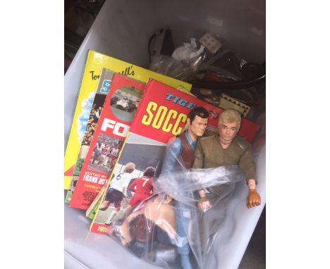 A box of misc items including football annuals, Action Man toys and a silver jubilee mug, badges, etc. 