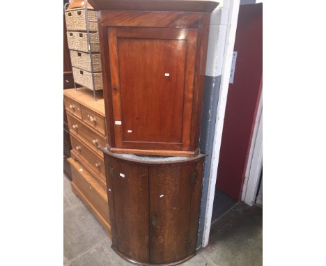 A 19th century mahogany corner cupboard together with an oak Georgian bow front corner cupboard 