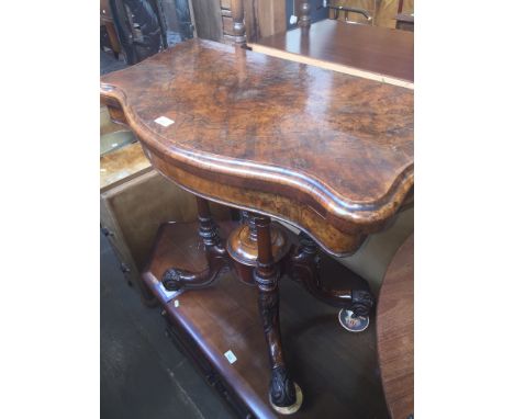 A 19th century burr walnut veneered pedestal folding games table with four turned pillar supports, carved splayed legs and sc