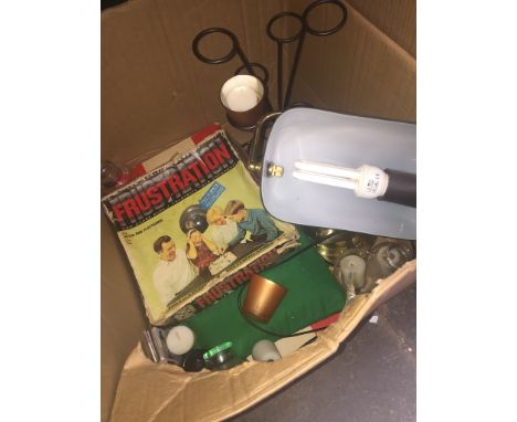 A box of various items including green glass desk lamp, vintage games, etc. 