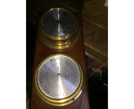 A clock and barometer on wooden plinth 