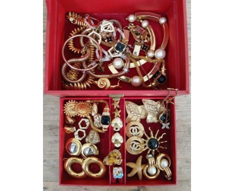 A red box containing gold plated costume jewellery, various makes including Monet, Napier, Butler and wilson etc.