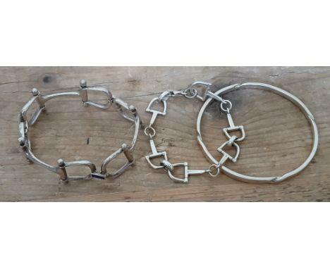 Two equestrian themed bracelets: one modelled as linked horse bits and the other linked stirrups, together with a bangle, all