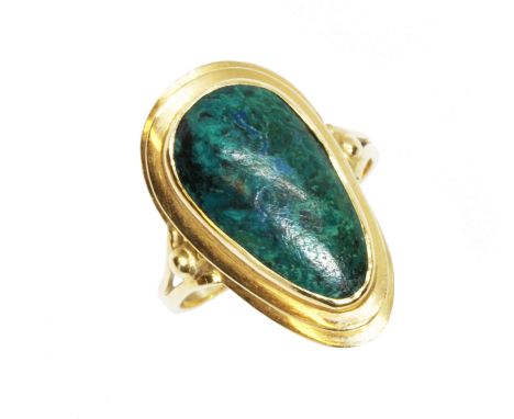 A foreign yellow metal ring set with a green cabochon, indistinctly marked, gross weight 3.6g, size K.  Condition - general w