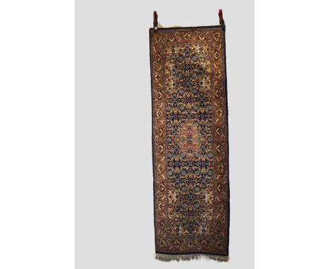 Kashmir(?) long rug, north India, second half 20th century, 6ft. 1in. X 2ft. 1.86m. X 0.61m. Dark blue field with ivory spand