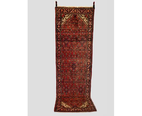 Hamadan runner, north west Persia, mid-20th century, 10ft. 1in. X 3ft. 4in. 3.07m. X 1.02m. Light red field with all over her