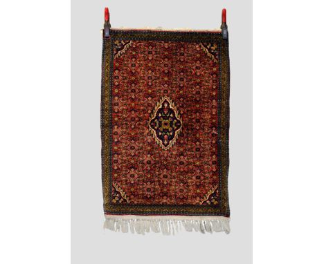 Bijar rug, north west Persia, circa 1950s, 3ft. 3in. X 2ft. 3in. 1m. X 0.69m.  Small dark blue centre medallion on a light re