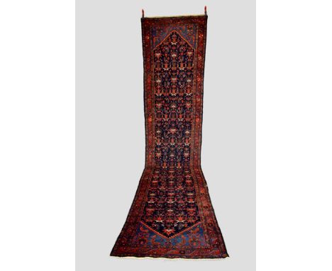 Malayer runner, north west Persia, circa 1930s, 15ft. 11in. X 3ft. 6in. 4.85m. X 1.07m. Slight wear in places.  Dark blue fie